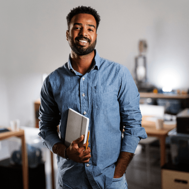 Imagem de um homem feliz segurando um caderno